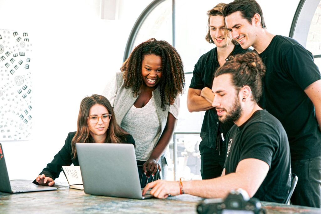Dynamic team of young adults collaborating on project in bright modern office environment.